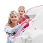 Technik ustawia pacjentkę przy mammografie Planmed Clarity 2D/3D
