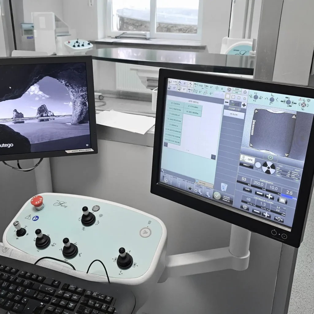 Konsola sterownicza z joystickami i monitorami w pracowni RTG w Dęblinie