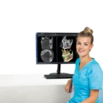 Technik przy monitorze z obrazami z tomografu Planmeca Viso G5