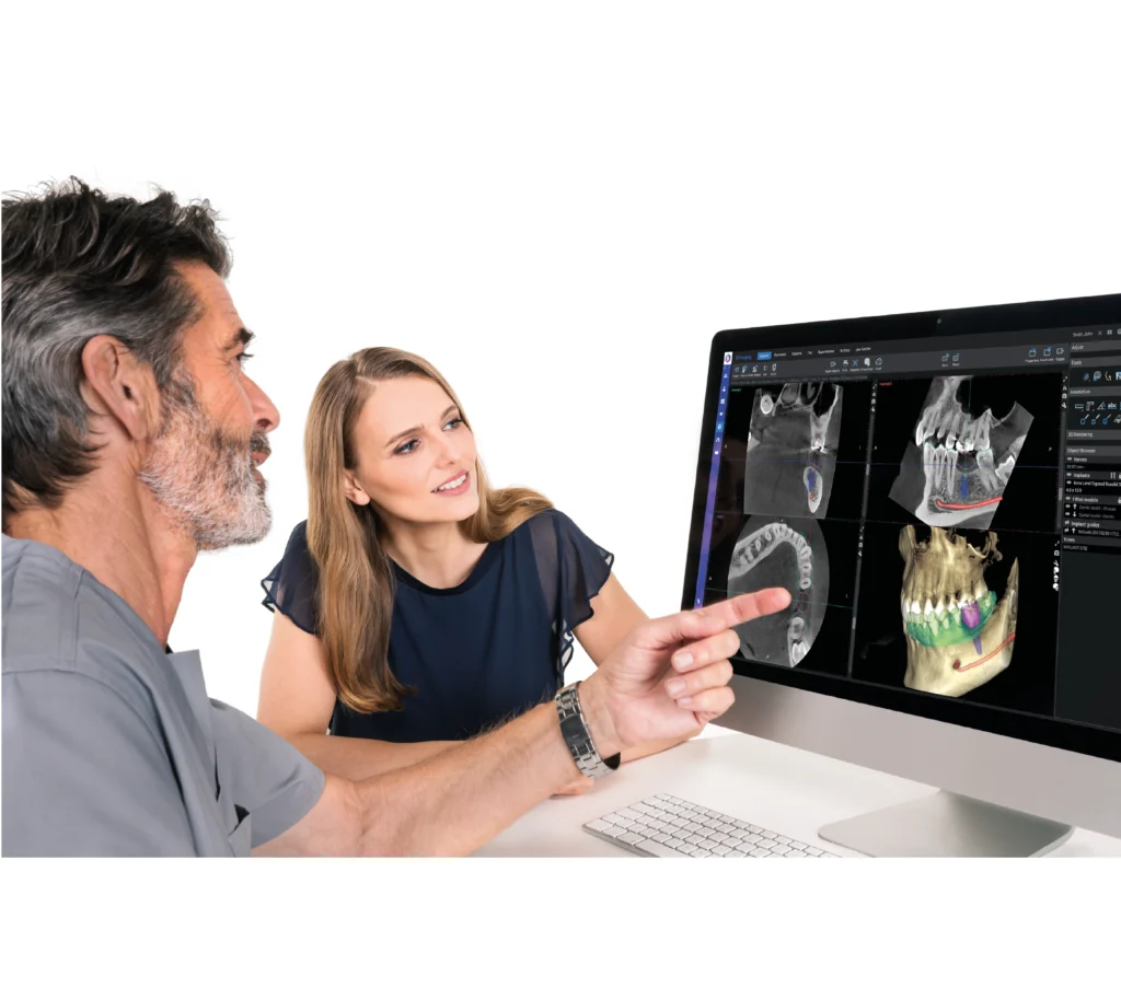 Stomatolog omawia z pacjentami skan 3D z tomografu Planmeca Viso G7