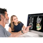 Stomatolog omawia z pacjentami skan 3D z tomografu Planmeca Viso G7