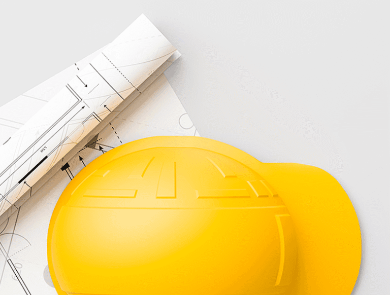 Żółty kask budowlany na projektach technicznych placówki szpitalnej
