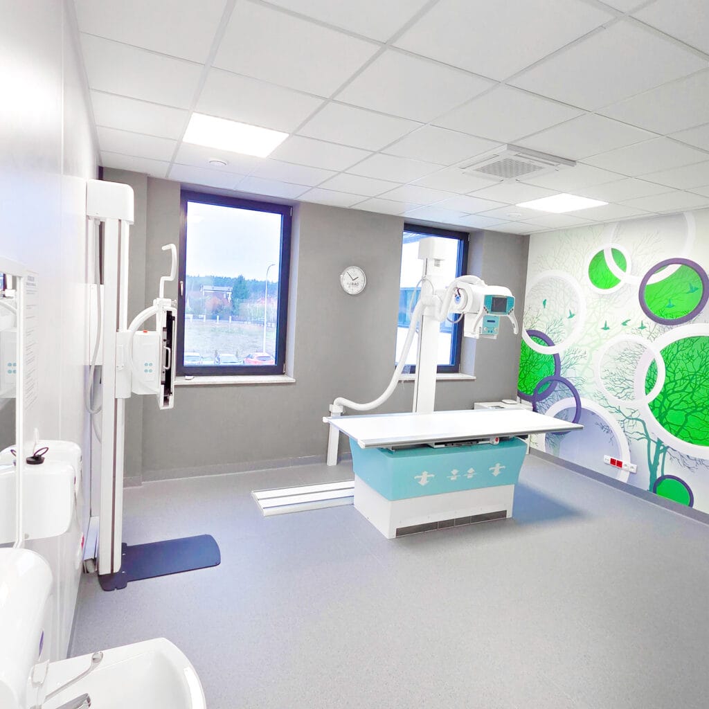 Pracownia RTG w Nadarzynie z aparatem, stołem i grafiką ścienną